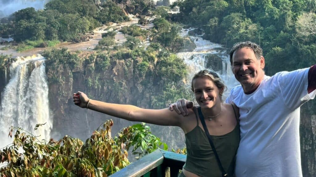 People posing near a waterfall in iguazu argentina private tour
