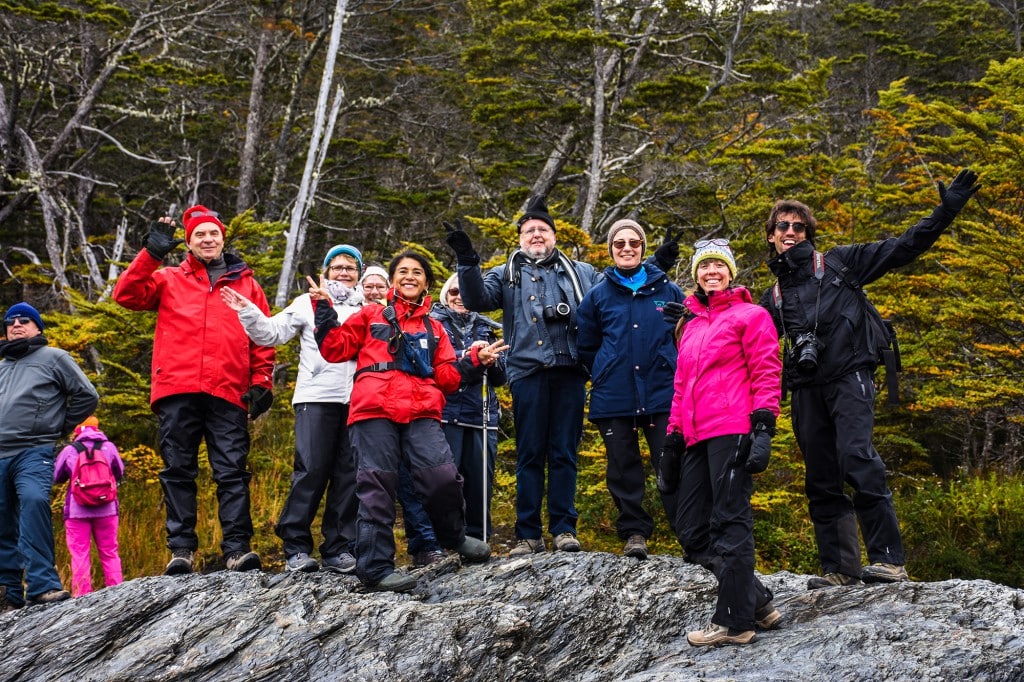Travelers walking through the landscape at Wulaia during a Patagonia expedition cruise